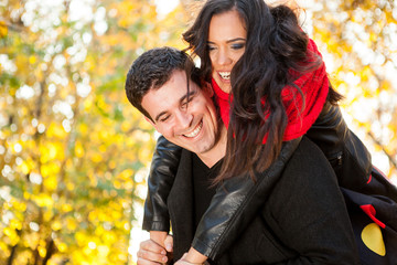Fototapeta premium Amazing funny young couple in autumn park having fun