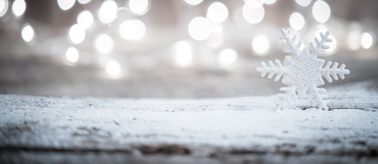 Snowflake ornament over blurred lights as holiday background