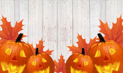 Autumn carved pumpkin pumpkin with yellow leaves on a wooden background - 181539970