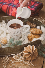 Obraz na płótnie Canvas pour the milk into a mug of cocoa and Christmas decorations