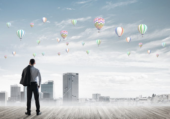 Motivation and inspiration concept with modern cityscape and businessman observing it