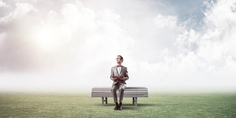 Young businessman or student studying the science in summer park