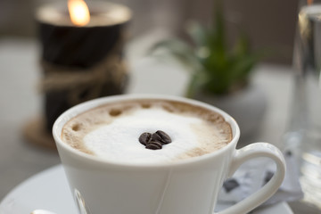 Coffee cream milk in bar romantic candle close top view beans