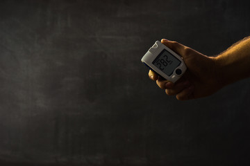 Human hand, Glucometer on a dark background of sugar in the blood. The concept of diabetes