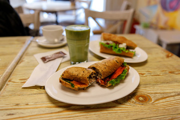 Salmon sandwich with matcha latte in the bakery, lunch