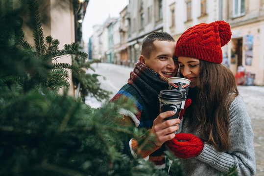 Young Loving Happy Couple With Coffee Cups On The Street In Winter