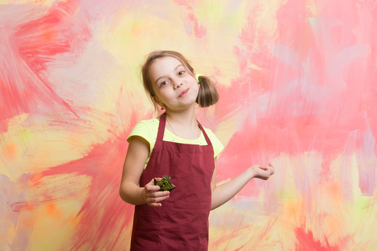 Baby cook in red chef apron on colorful abstract wall