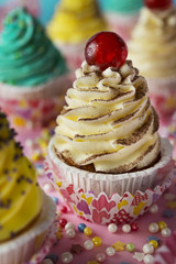 Colorful cupcakes on a pink background with decoration