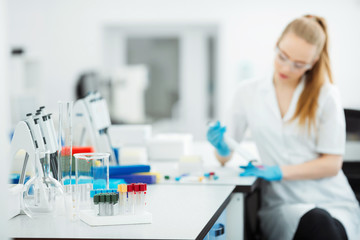 Pipette dropping a sample in a test tube. Laboratory assistant analyzing blood in lab. Aids, hiv...