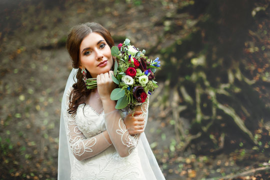 Young bride near old tree in forest
