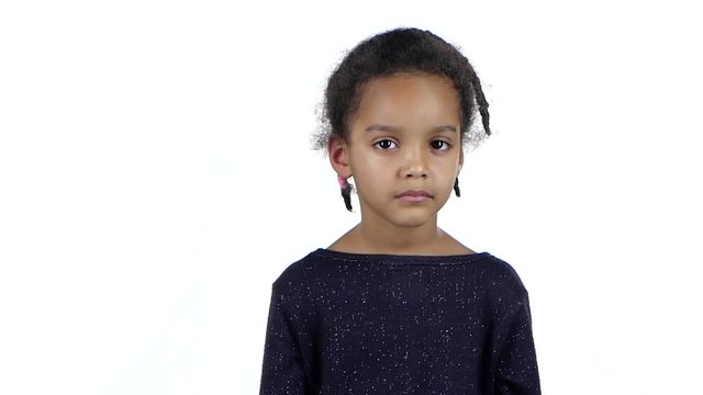 Child of an african american girl is sad. White background. Slow motion