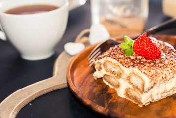Homemade tiramisu cake decorated with strawberries Italian cuisine, Selective focus