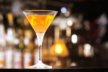 Fresh tall glass of tropical cocktail with rum and orange juice at bar counter background.