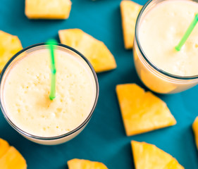 sliced pineapple with a glass of pineapple juice on a blue wooden background