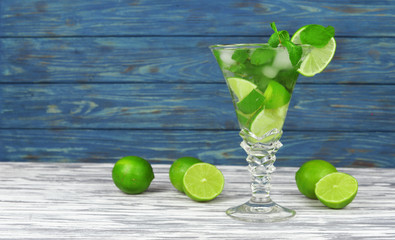 delicious fresh drink cocktail mojito from lime and mint with ice in a beautiful glass on a wooden background