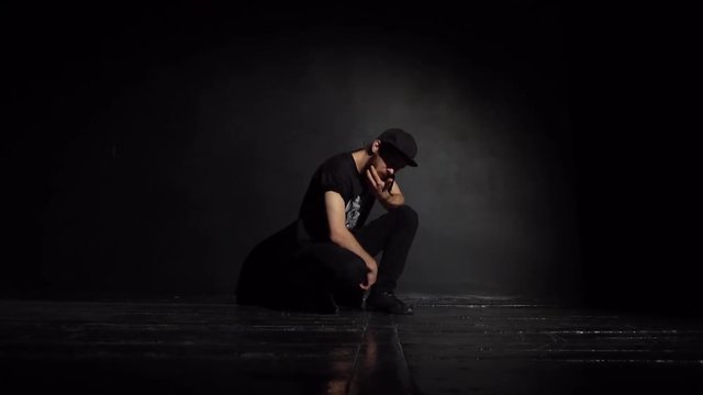 Guy breakdancer posing in a black studio