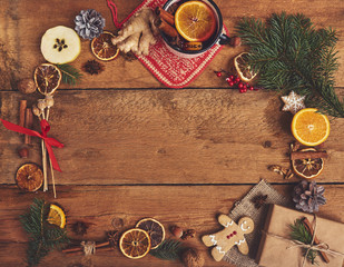 Mulled wine in rustic mug with spices and ingredients on wooden background. Top view, flat lay. Copy space for your text.