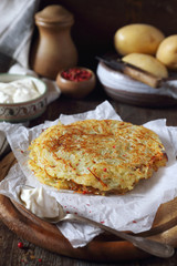 French cuisine. Pomme darphin: roasted pancakes from raw grated potatoes with sour cream