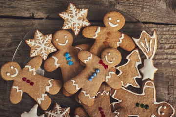 Smiling gingerbread christmas men over wood board. Space for text