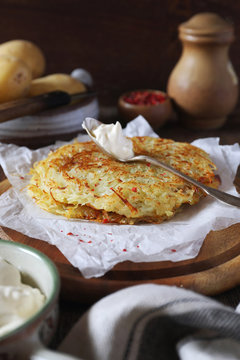 French cuisine. Pomme darphin: roasted pancakes from raw grated potatoes with sour cream