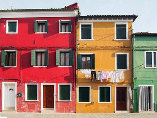 colourfull painted houses on a street in burano in venice in bright summer sunlight