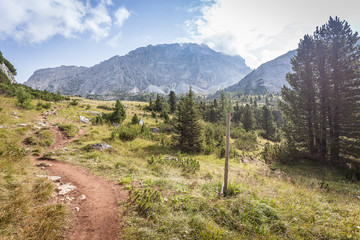 Reddish path with dolomitic background, Valparola Pass, Dolomites, Italy