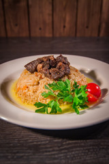 A tasty dish of rice on a plate. On a wooden background