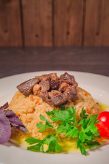 A tasty dish of rice on a plate. On a wooden background