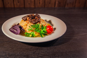 A tasty dish of rice on a plate. On a wooden background