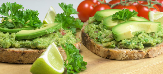 Fototapeta na wymiar Healthy dish - guacamole sandwich on the wooden board- closeup.