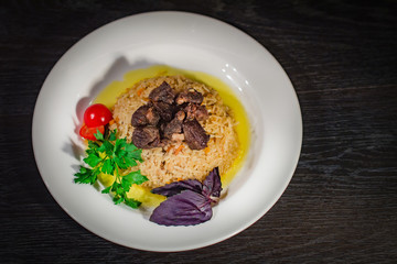 A tasty dish of rice on a plate. On a wooden background