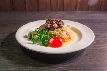 A tasty dish of rice on a plate. On a wooden background
