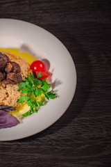 A tasty dish of rice on a plate. On a wooden background