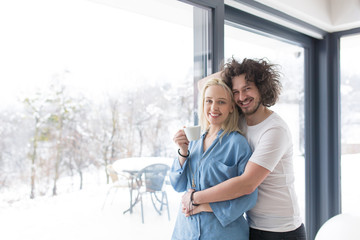 young couple enjoying morning coffee by the window