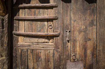 antique brown wooden door with a small door knocker 