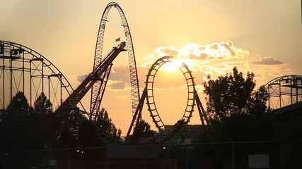 Wide, sunset over roller coaster ride