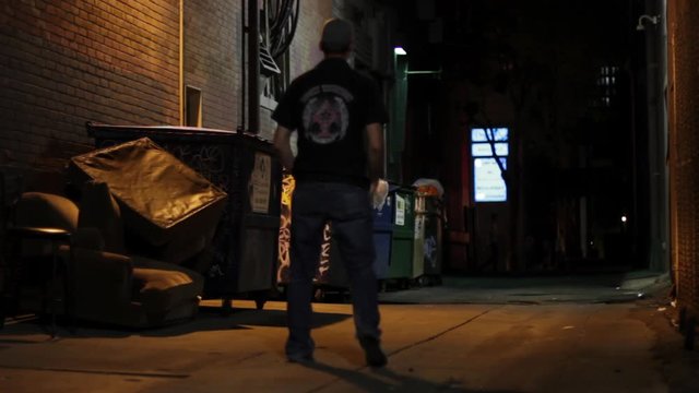 Drunk man walks in alleyway