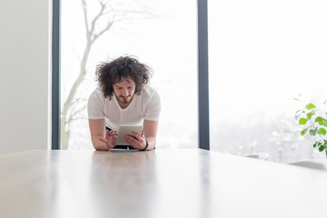 young man using a tablet at home