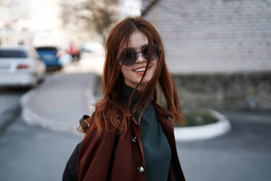 Young beautiful girl in sunglasses walking on the street