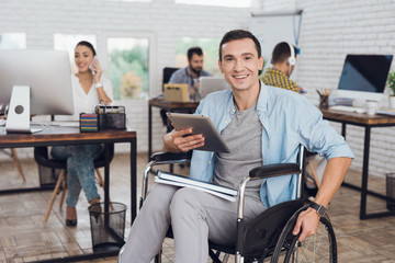 Disabled person in the wheelchair works in the office.