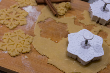 preparing Christmas cookies on a kitchen countertop, wooden starboard shaped boards and a green dough roll