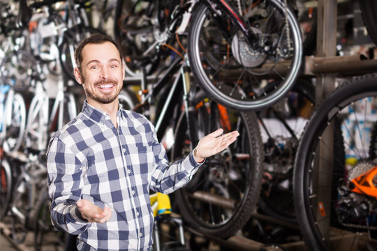 young man in bicycle shop chooses for himself sports bike