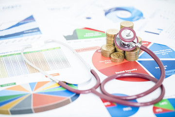 Stethoscope checking stack of money coins are placed on the annual financial statements, concept of financial diagnosis or financial health check