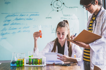 Couple of students working at chemistry class. Education concept