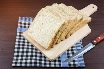 Sliced Whole wheat bread on Chopping Wood and tablecloth background