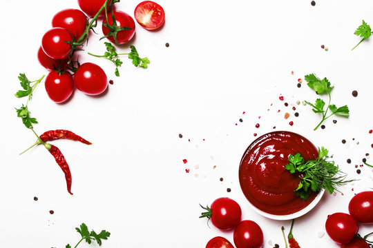Tomato ketchup sauce with spices and herbs with cherry tomatoes in a bowl on white food background, top view