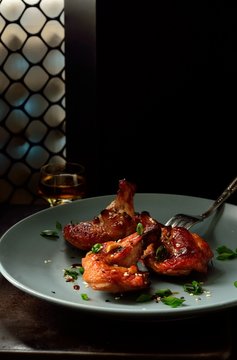 Roasted pieces chicken wings in sauce with sesame seeds and green onions