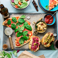 Dinner table with various food for company, top view