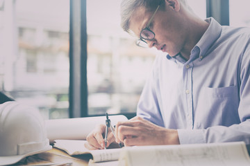 Engineer sketching architectural project on blueprint