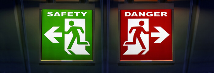 The signpost shows two path directions. Choice of way, green safety and red dangers. The emergency...